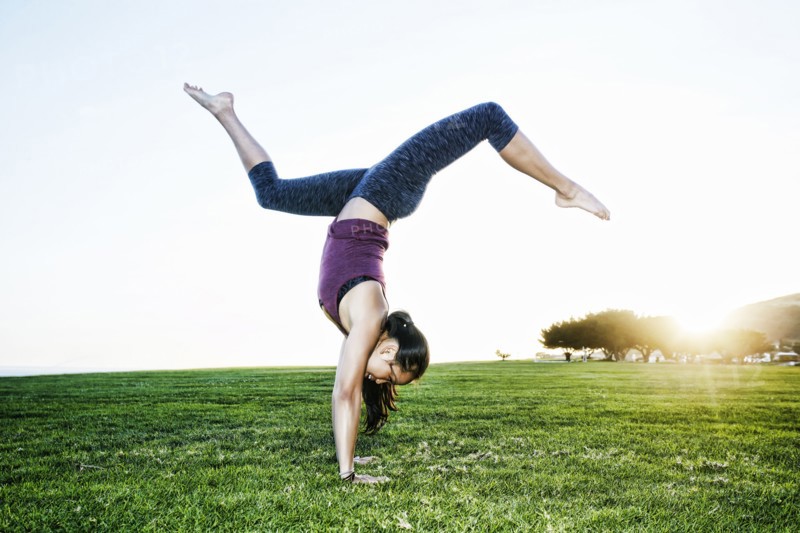 Asian woman practicing yoga outdoors