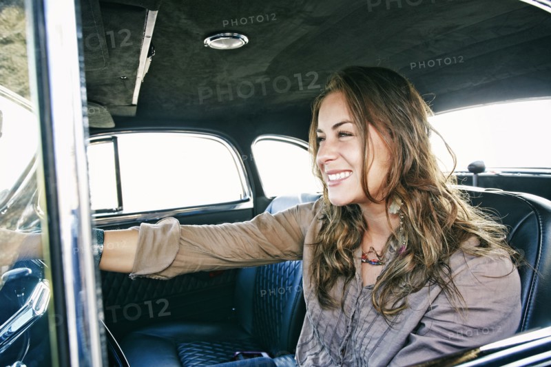 Mixed race woman driving vintage car