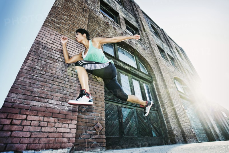 Mixed race woman jogging on sidewalk