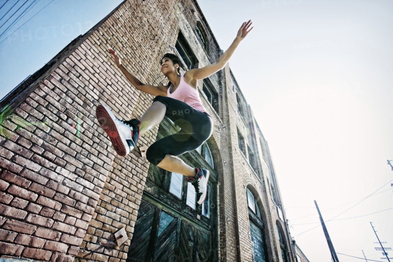 Mixed race woman jumping outdoors