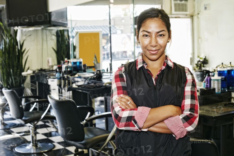 Hispanic hairstylist smiling in salon