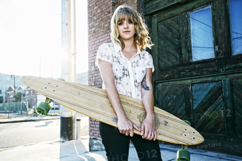 Caucasian woman carrying skateboard