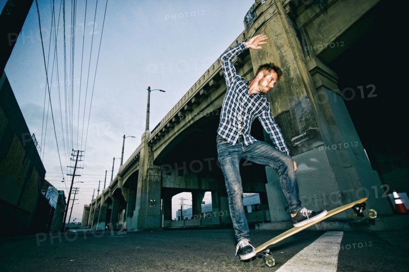 Caucasian man riding skateboard outdoors