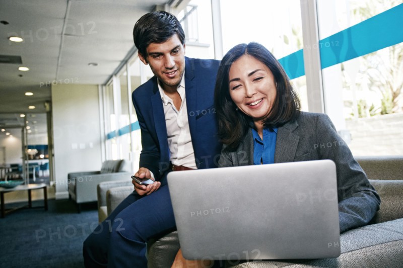 Business people using laptop in office