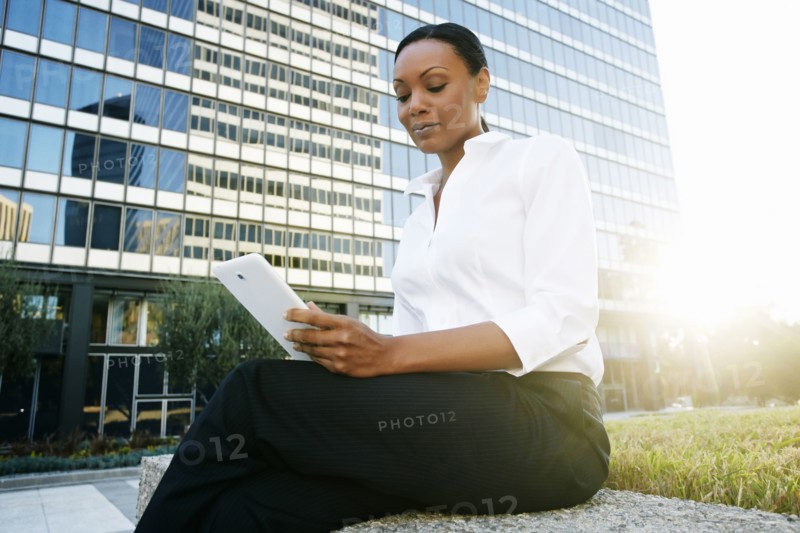 Black businesswoman using digital tablet outdoors