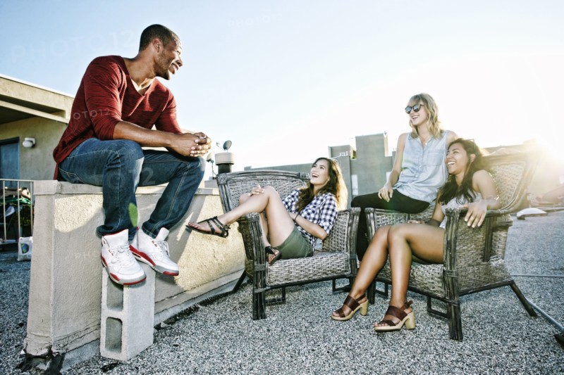 Friends relaxing on urban rooftop