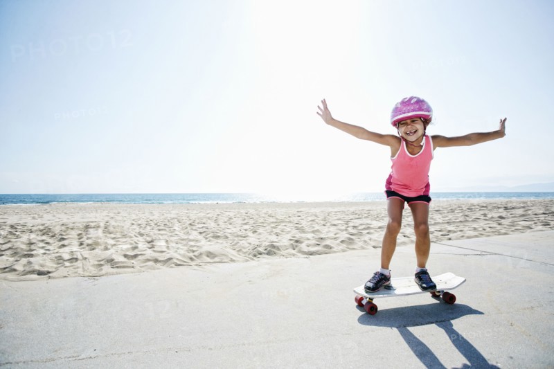 Girl riding skateboard at beach
