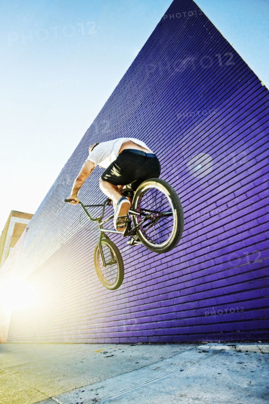 Caucasian man jumping on BMX bike