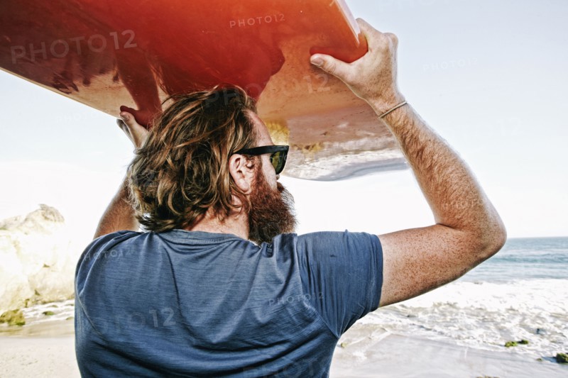 Caucasian man holding surfboard at beach