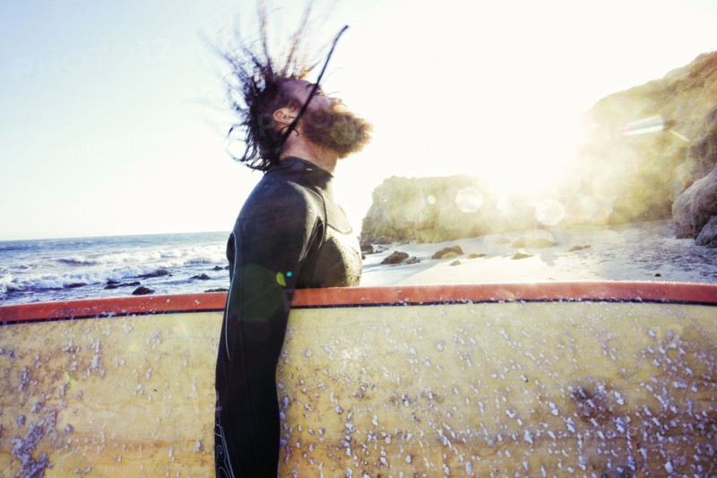 Caucasian man holding surfboard at beach