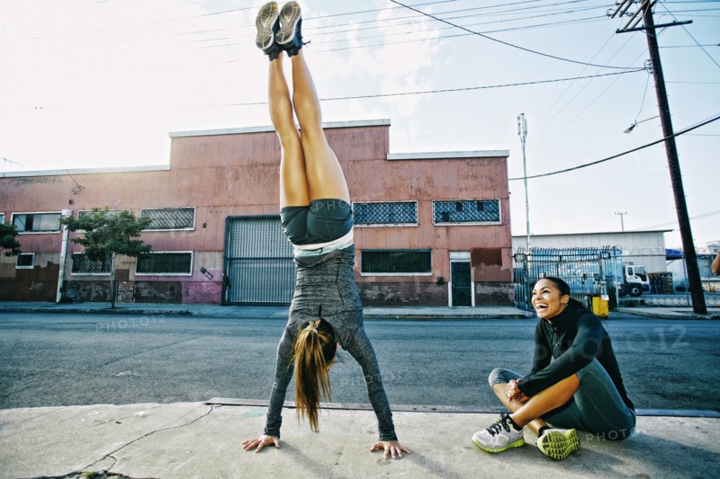 Athlete doing handstand on sidewalk