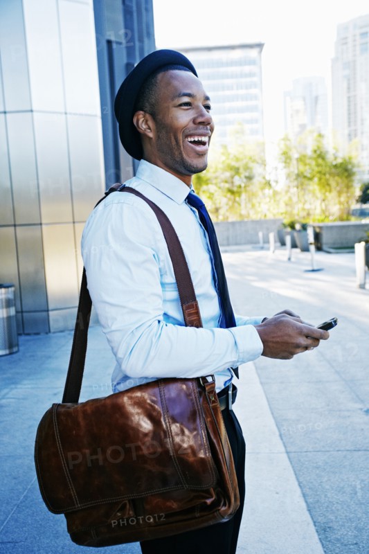 Black businessman using cell phone outside office building