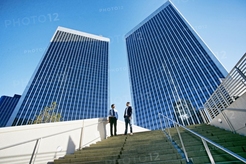 Businessmen talking under highrise buildings