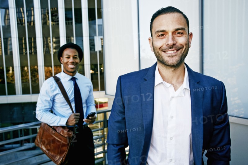 Businessmen smiling outside office building