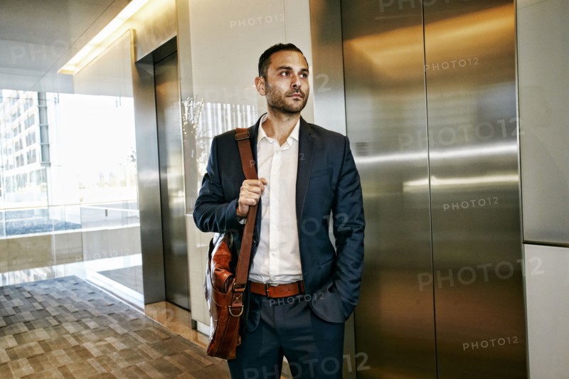 Caucasian businessman waiting for office elevator