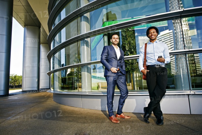 Businessmen smiling outside office building