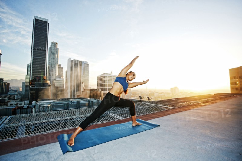 Mixed race woman practicing yoga on urban rooftop