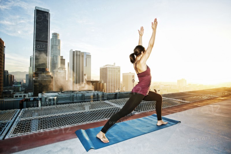 Mixed race woman practicing yoga on urban rooftop