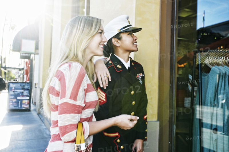 Asian soldier and friend window shopping