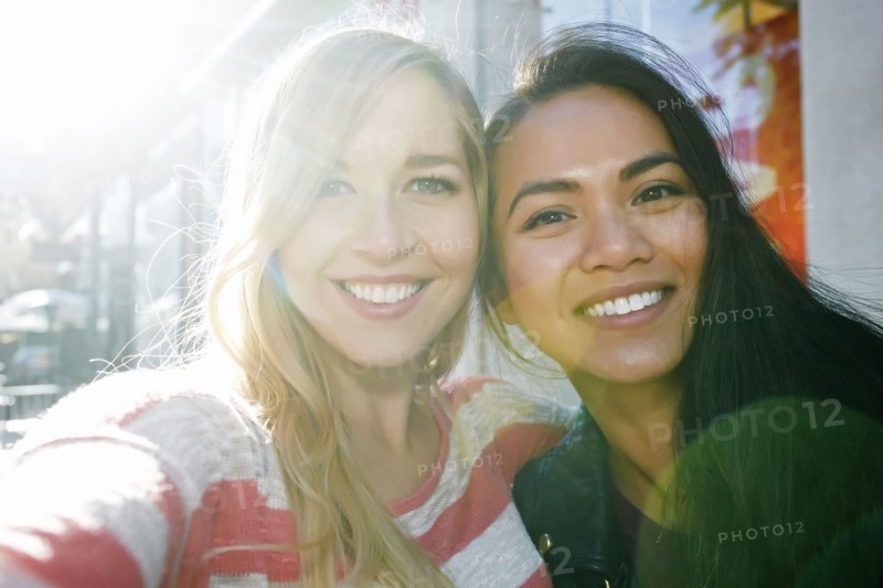 Close up of smiling women hugging outdoors