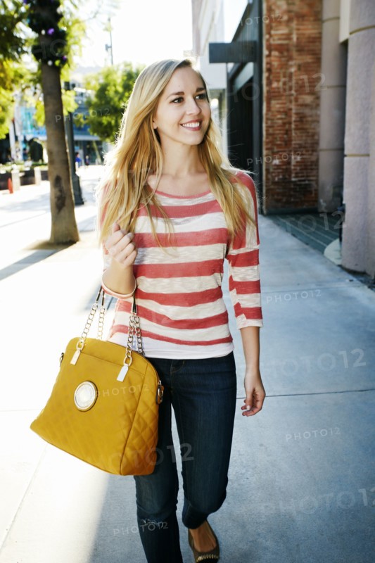 Caucasian woman walking on sidewalk