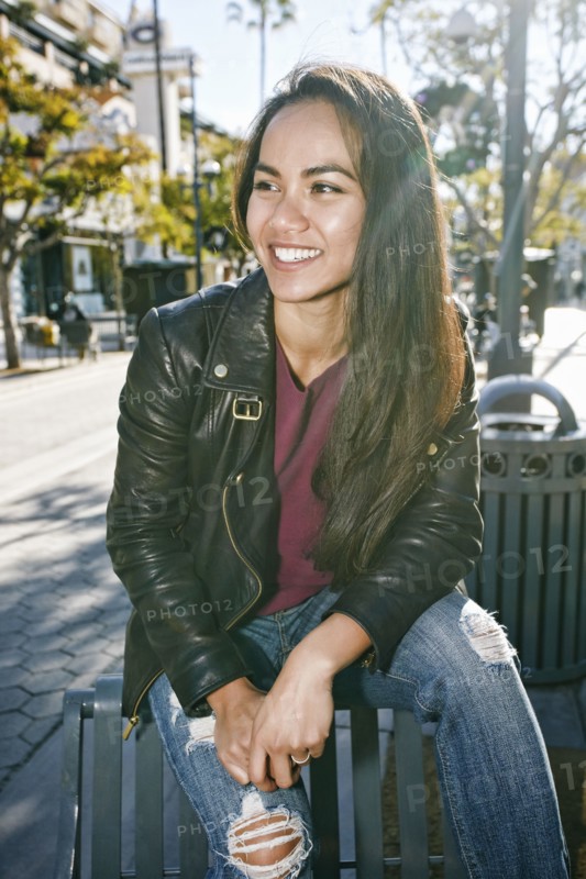 Asian woman sitting on city bench