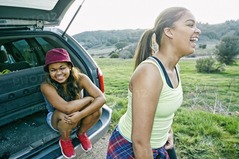 Mixed Race at hatch of car laughing