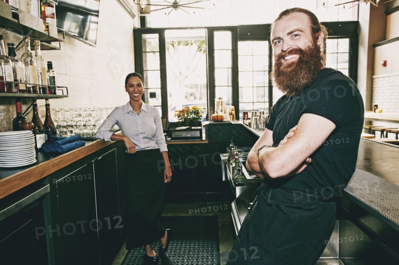 Smiling bartenders relaxing behind bar