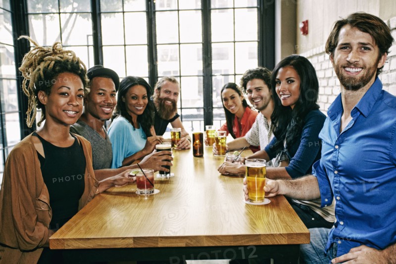 Smiling friends posing at table in bar