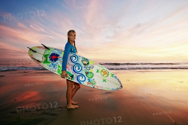 Caucasian woman carrying surfboard at beach