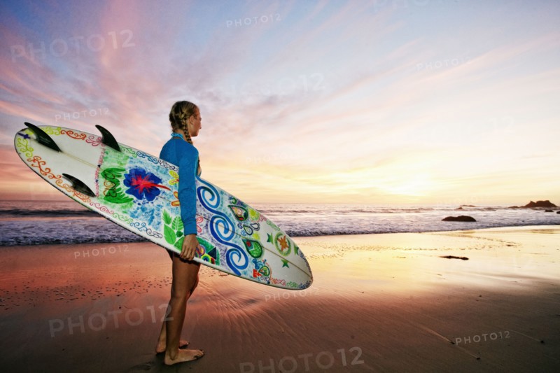 Caucasian woman carrying surfboard at beach