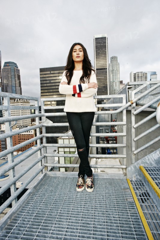 Serious Hispanic woman posing on urban metal staircase