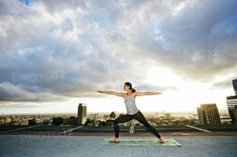 Caucasian woman stretching on urban rooftop