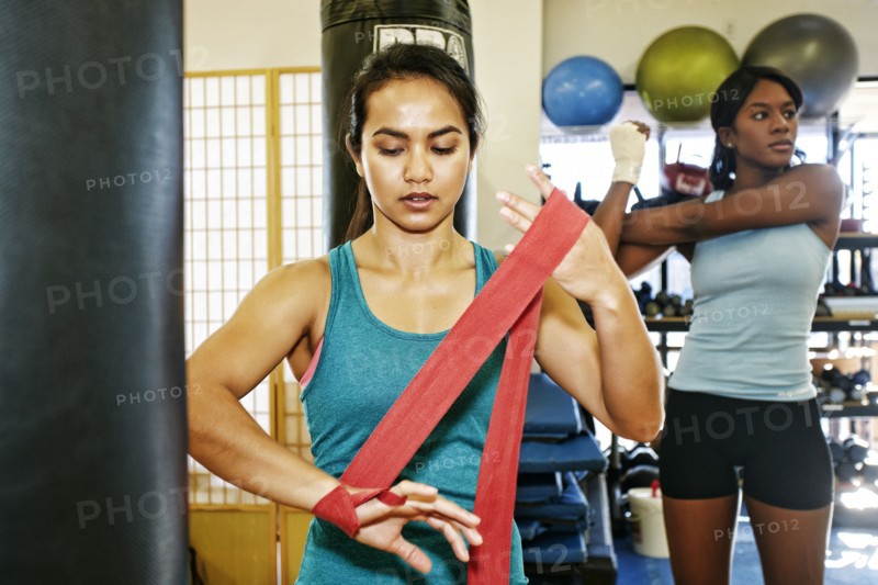Woman wrapping hand in gymnasium
