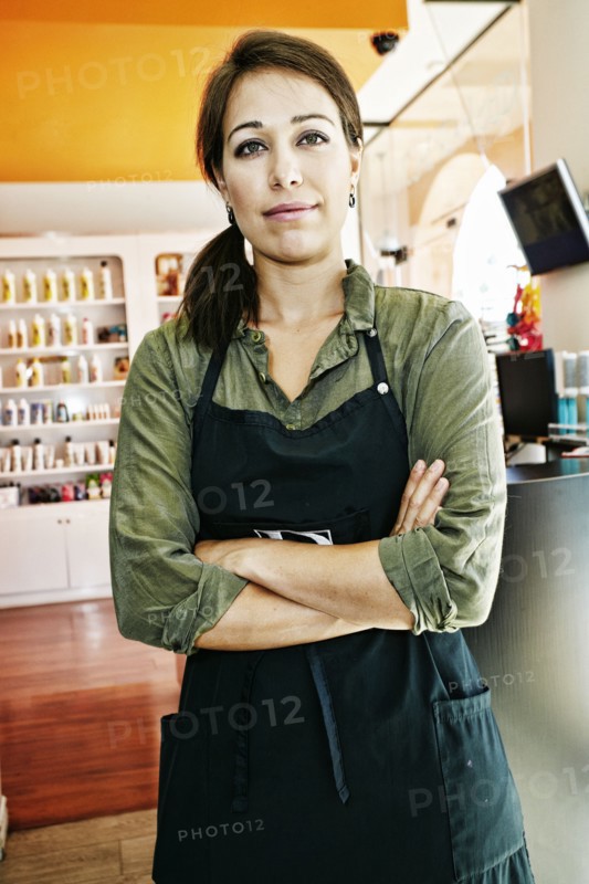 Serious Mixed Race hairdresser posing in hair salon