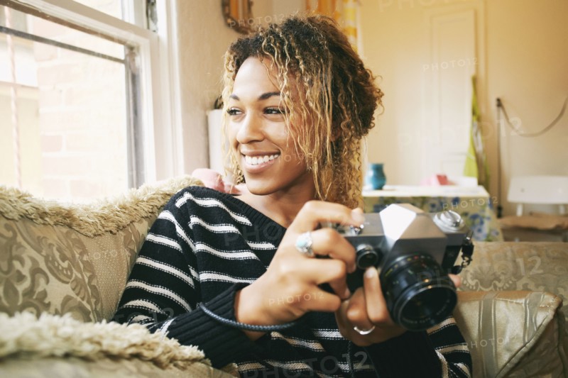 Smiling Mixed Race woman holding camera