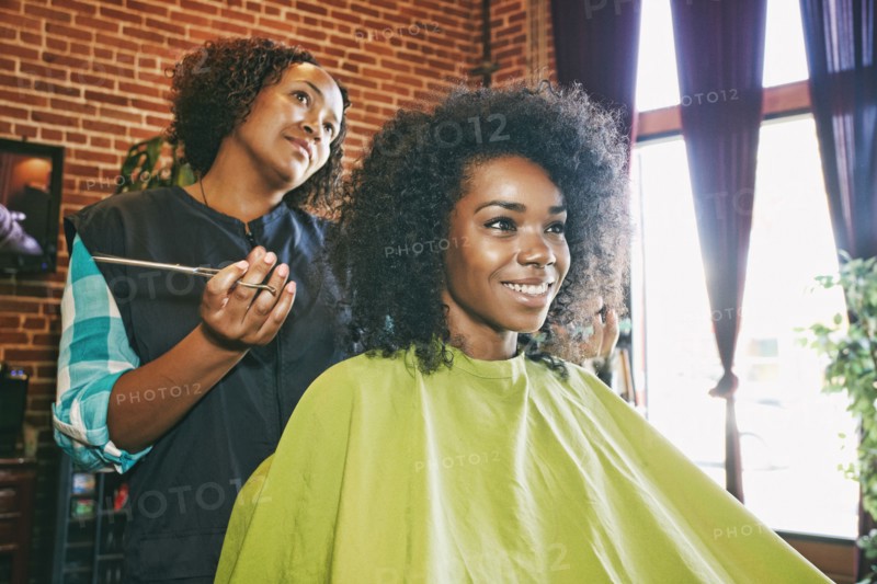 Smiling hairdresser and customer in hair salon