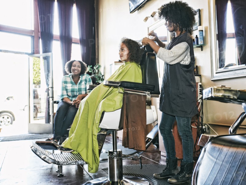 Smiling hairdresser and customers in hair salon