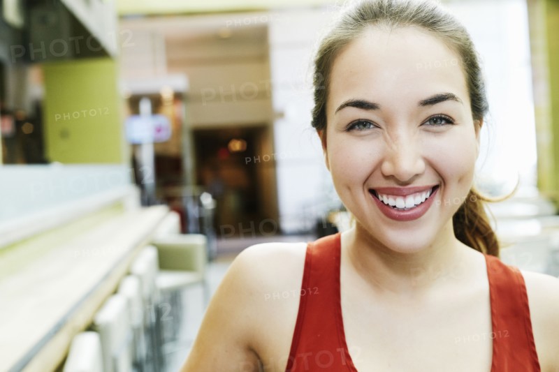 Smiling Mixed Race woman posing in food court