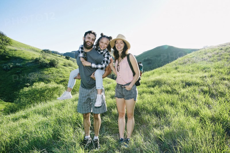 Portrait of happy family standing on hill
