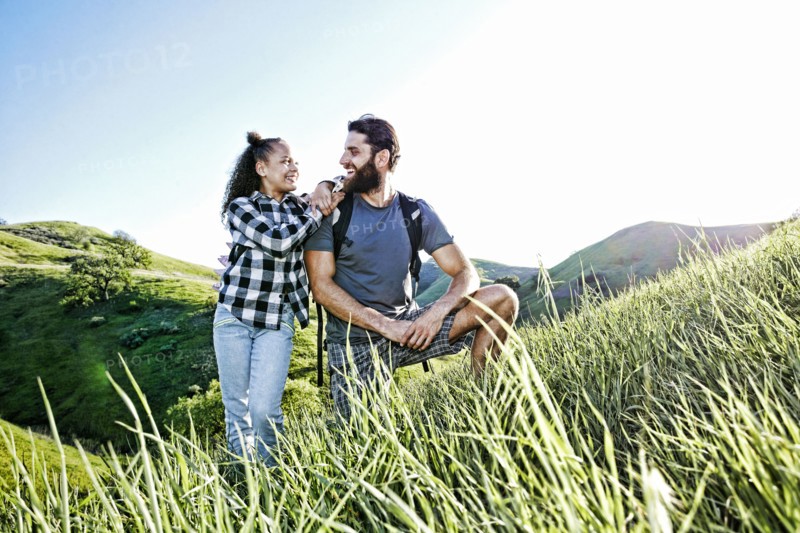 Father and daughter smiling on hill