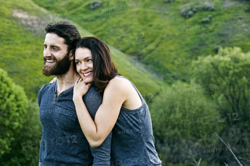 Smiling couple standing on hill