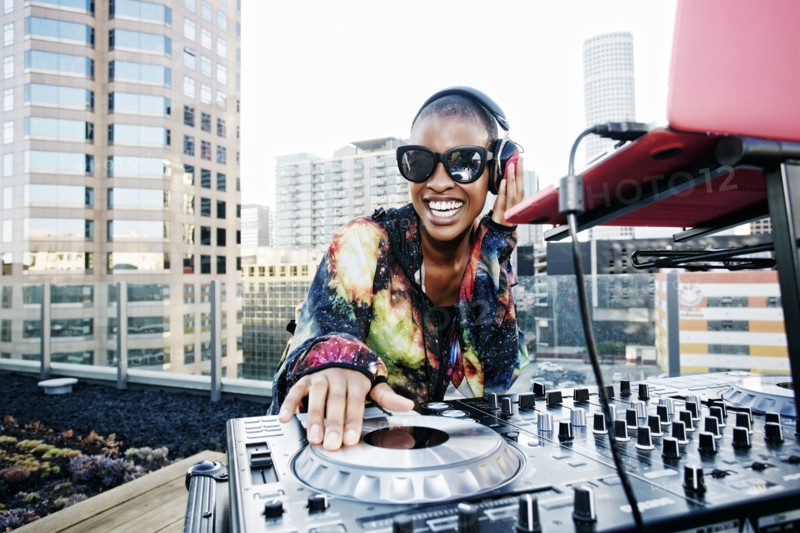 Smiling Black DJ on urban rooftop