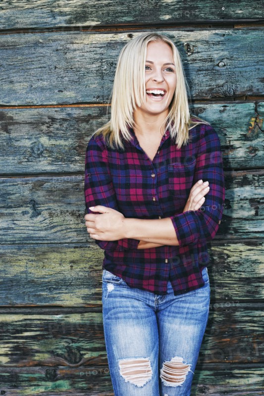 Portrait of smiling Caucasian woman leaning on wooden wall