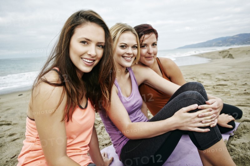 Portrait of smiling Caucasian women sitting on beach