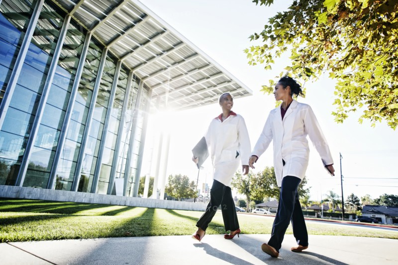 Doctors walking and talking outdoors at hospital