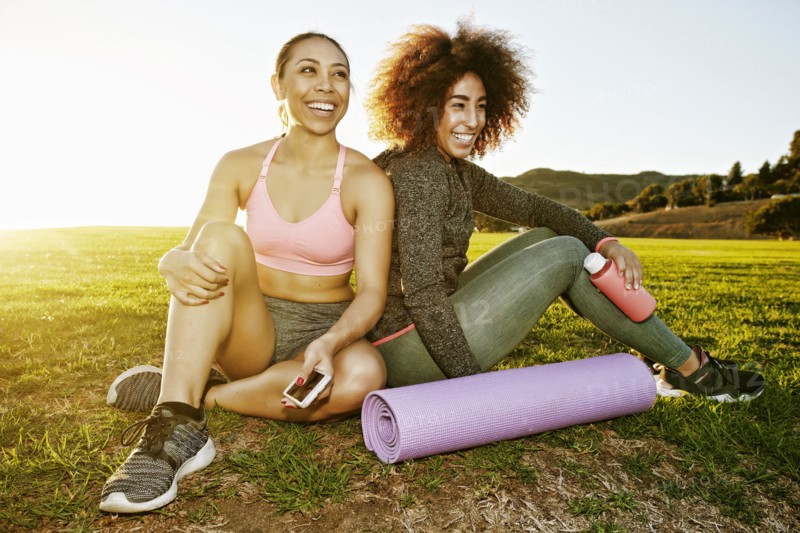 Smiling women sitting in sunny field