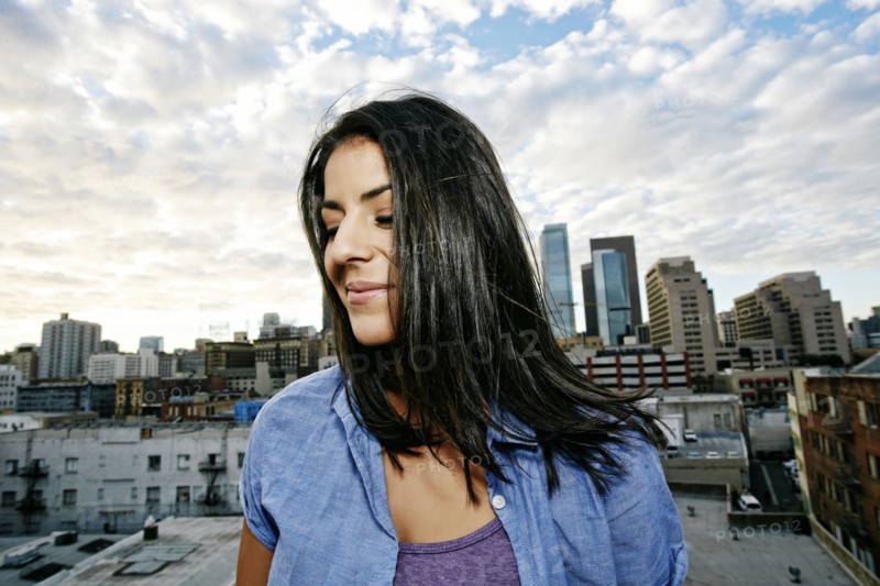 Portrait of smiling Hispanic woman on urban rooftop