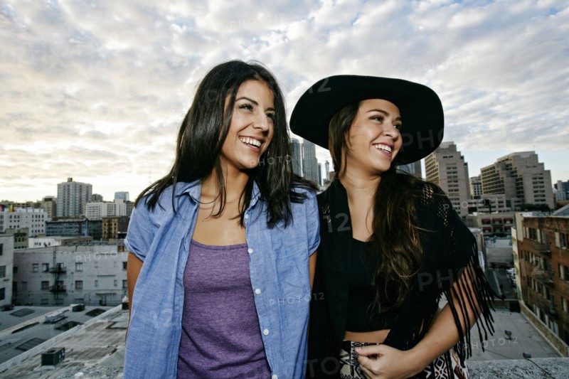 Smiling Hispanic women on urban rooftop