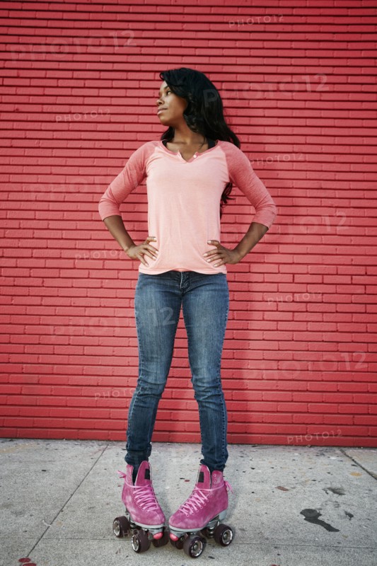 Black woman wearing roller skates on sidewalk